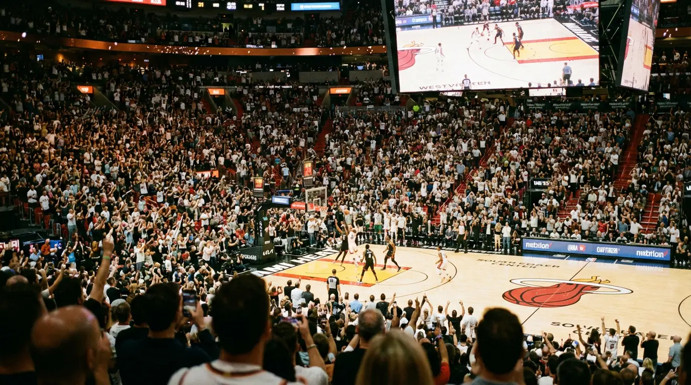 Aficionados viendo un partido de baloncesto en directo en un estadio con el marcador electrónico visible